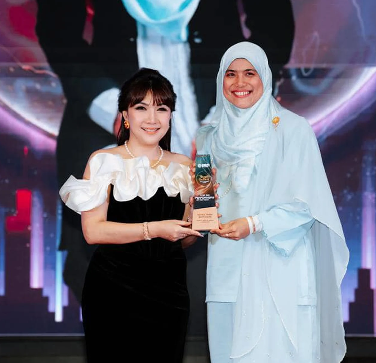Huda receiving an award for her real estate performance
